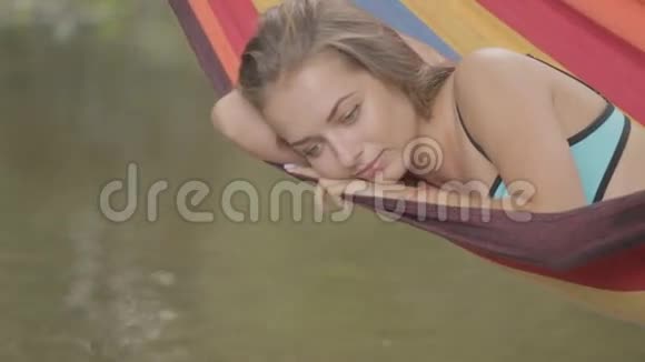 美丽的女孩坐在吊床上翻水视频的预览图