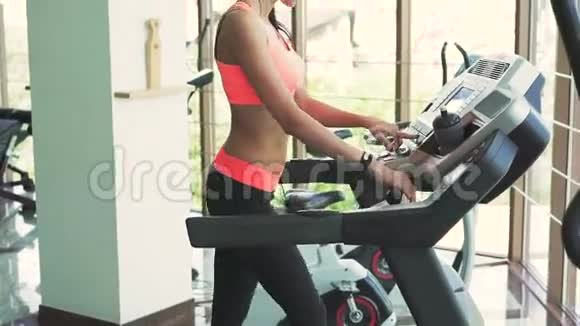 年轻健康的女人在跑步机上跑步视频的预览图