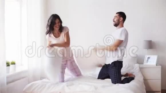 快乐的一对夫妻在家睡觉打枕头视频的预览图