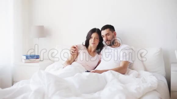 快乐的一对夫妇在家睡觉看电视视频的预览图