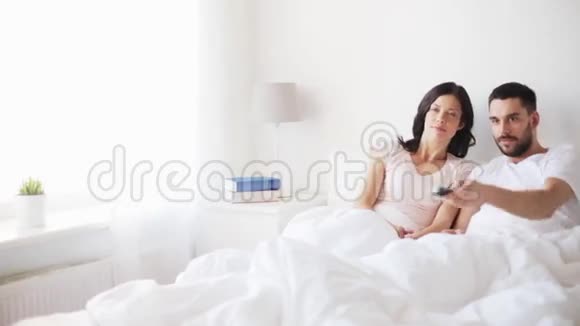 快乐的一对夫妇在家睡觉看电视视频的预览图