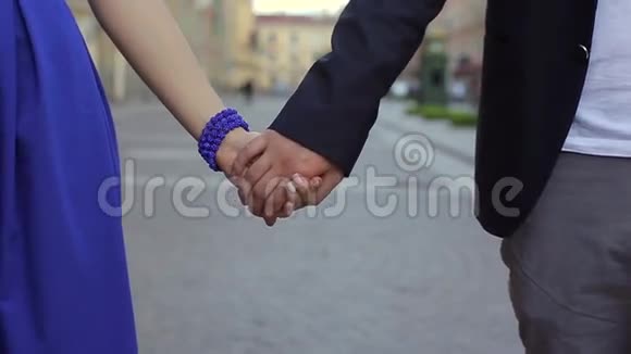 年轻可爱的一对手牵着手在城市里散步视频的预览图