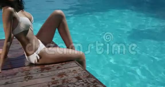 迷人的女人在游泳池旁放松视频的预览图