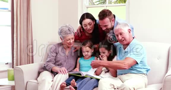 一家人一起在沙发上笑看书视频的预览图