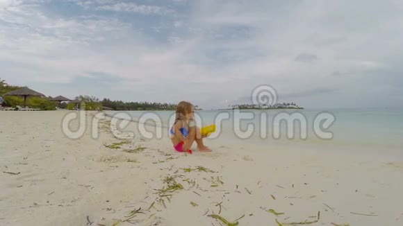 可爱的小女孩在白海滩热带度假视频的预览图
