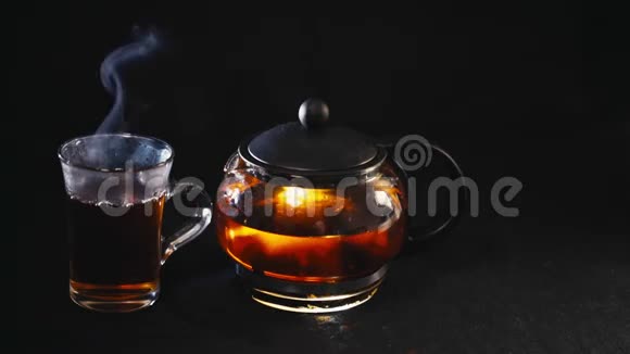 黑背景玻璃杯透明茶壶中的红茶视频的预览图