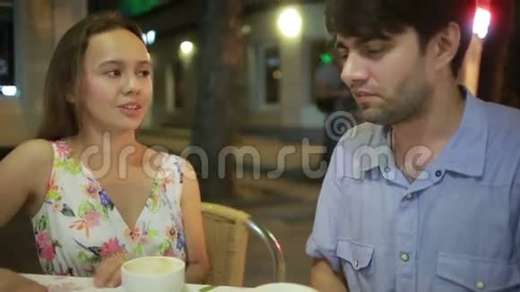 一对情侣在户外咖啡馆谈恋爱男人和美女约会视频的预览图