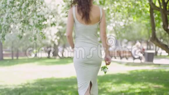 年轻女子在苹果树的背景下享受视频的预览图