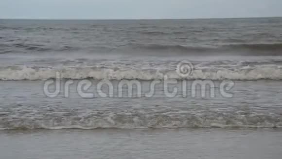 阳光明媚的一天海水向海滩冲浪视频的预览图
