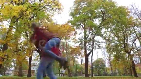 快乐的年轻夫妇在秋天公园玩得开心视频的预览图