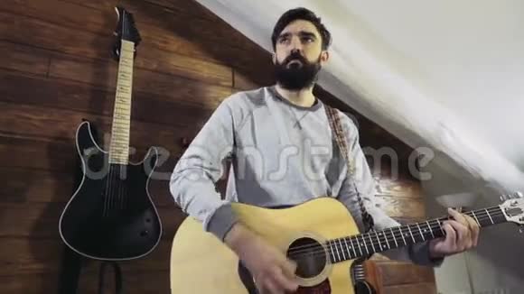 英俊的胡子男人弹吉他慢动作视频的预览图