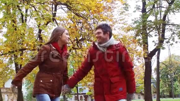 快乐的年轻夫妇在秋天公园玩得开心视频的预览图