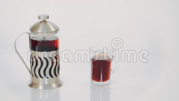透明茶壶配茶和白底热茶杯视频的预览图