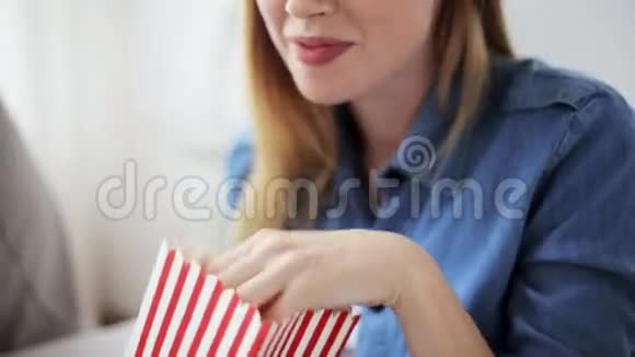 快乐的女人在家吃爆米花看电视视频的预览图
