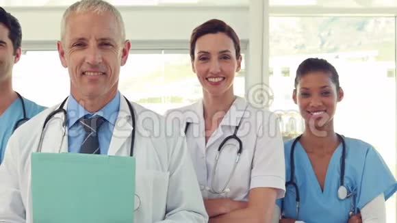 一队微笑的医生看着摄像机视频的预览图