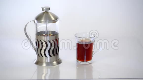 透明茶壶配茶和白底热茶杯视频的预览图