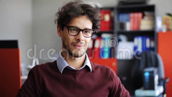 办公室里戴眼镜的年轻人微笑视频的预览图