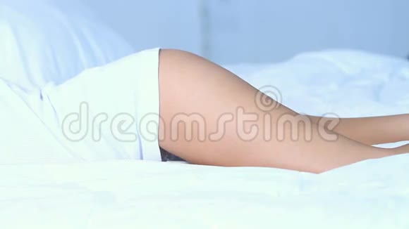 美丽的女人躺在白色的床上视频的预览图