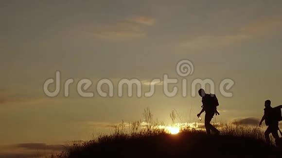 人们成群结队的游客走在大自然的山顶上一座旅游夕阳的剪影山慢速视频游客群视频的预览图