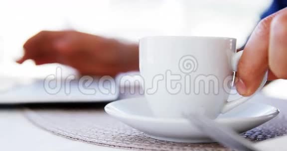 拿着咖啡杯用笔记本电脑的男人视频的预览图