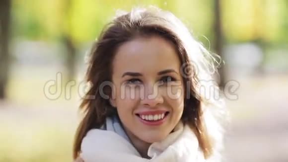 美丽快乐的年轻女子在秋天公园微笑视频的预览图