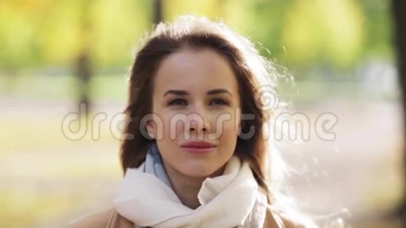 美丽快乐的年轻女子在秋天公园微笑视频的预览图