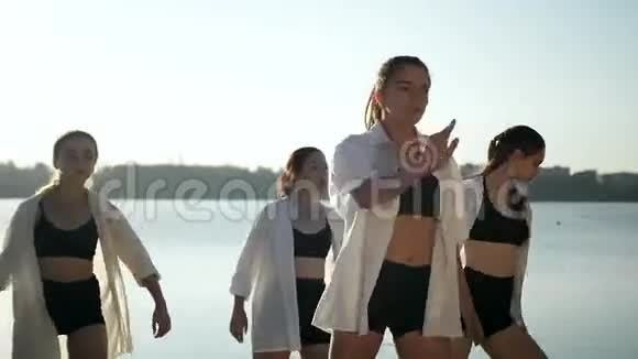 黎明时分四个女孩在湖边沙滩上跳舞视频的预览图