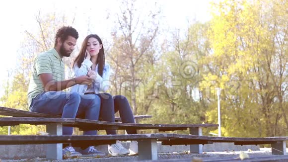 在公园听音乐的时候情侣们共用耳机视频的预览图