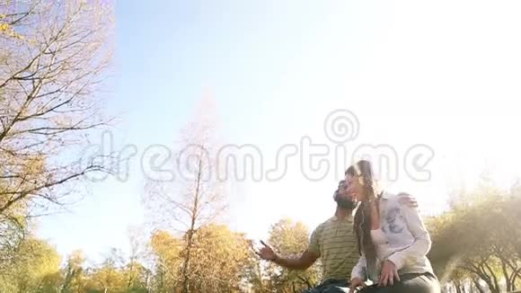 年轻夫妇在公园里用耳机听音乐玩得很开心视频的预览图