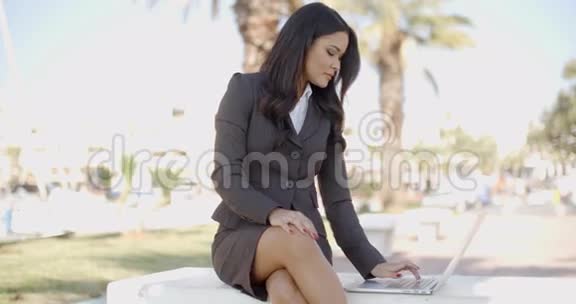 坐在长椅上的手提电脑商务女性视频的预览图