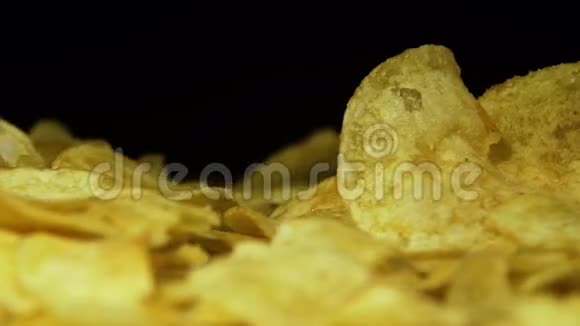 马铃薯芯片在黑色背景下旋转视频的预览图