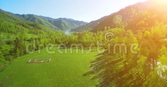 在阳光明媚的夏日早晨空中飞过新鲜的山河和草地农村土路下面视频的预览图