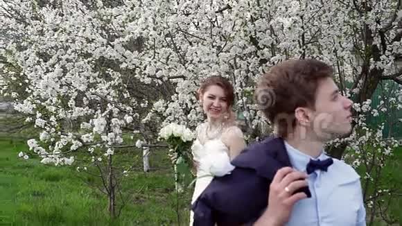 新郎新娘在盛开的春天花园里视频的预览图