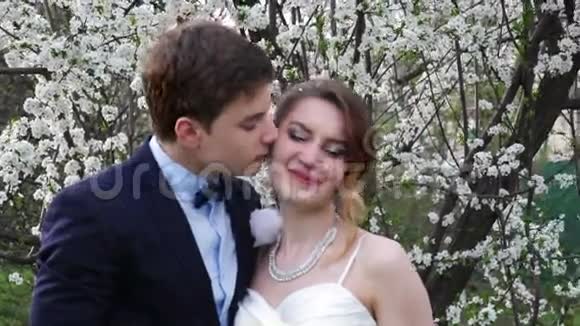 新郎新娘在盛开的春天花园里视频的预览图