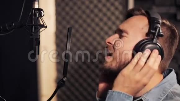 带着耳机在录音室唱歌的男人视频的预览图