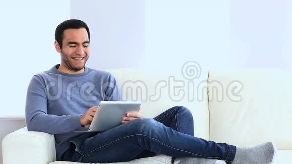 在沙发上用平板电脑的人视频的预览图