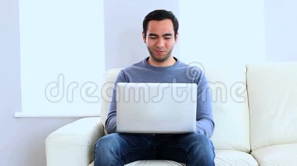 在沙发上用笔记本电脑的人视频的预览图