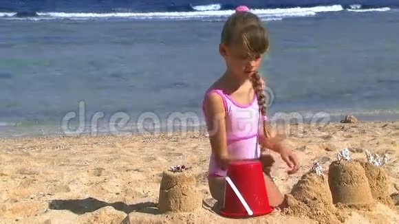 孩子们在海滩上玩耍建造沙堡视频的预览图