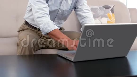 坐在沙发上用笔记本电脑的人视频的预览图