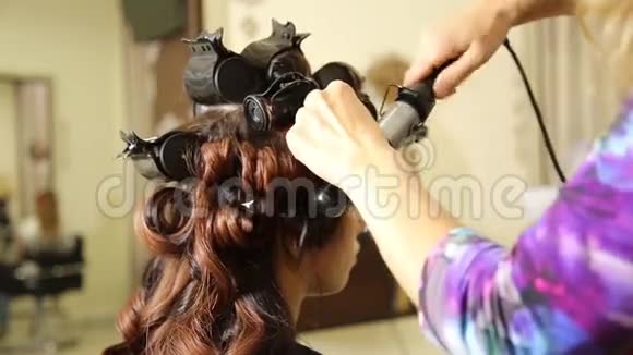 在美容院的时间年轻女子在美容院理发师给漂亮模特做发型视频的预览图