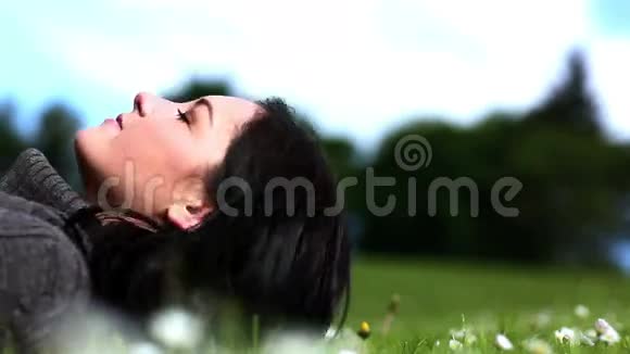 在公园里躺在草地上的女人视频的预览图