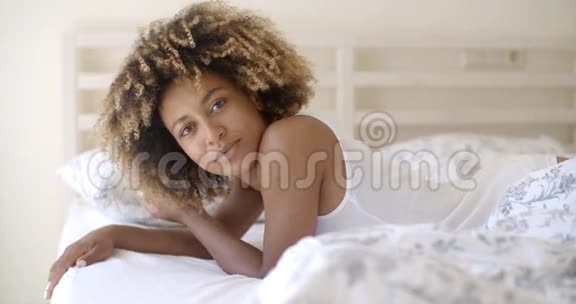 卧室里躺在床上的可爱女人视频的预览图