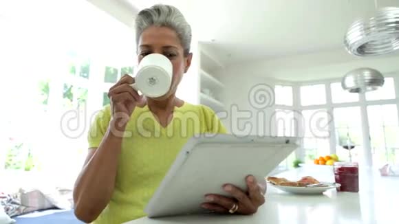 非洲裔美国妇女在家中使用数字平板视频的预览图