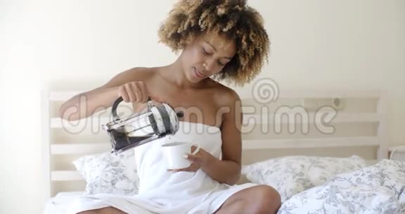 床上有一杯咖啡的漂亮女人视频的预览图