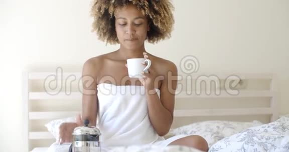 床上有一杯咖啡的漂亮女人视频的预览图