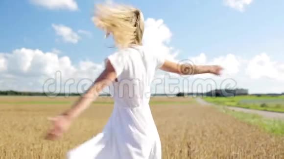 微笑着穿着白色衣服的年轻女子在麦田里视频的预览图