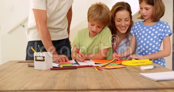快乐的父母和孩子们一起在餐桌上画画视频的预览图