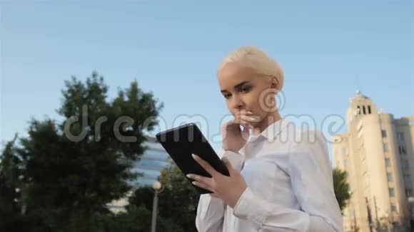 年轻美丽的商务女性使用平板电脑户外肖像视频的预览图
