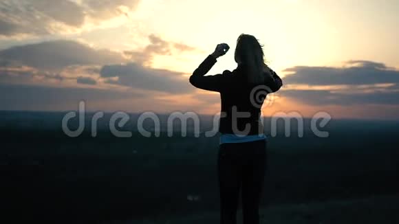 夕阳背景上美丽的女孩视频的预览图