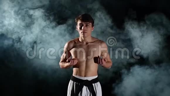 男子训练跆拳道或空手道的黑色视频的预览图